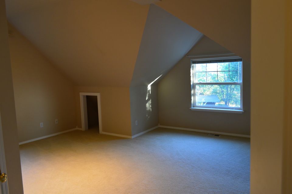 Vaulted bonus room with dormer window and fresh carpet inside a custom home built in Trout Creek MT