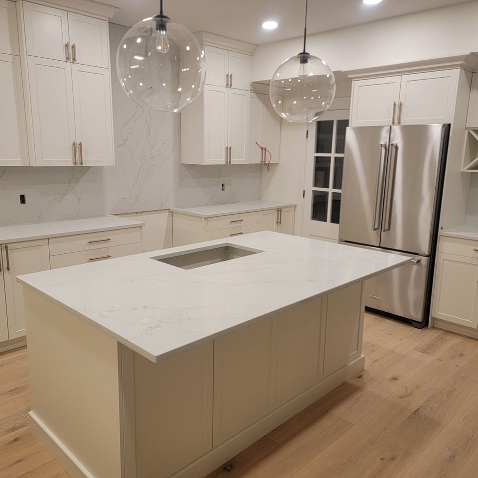 White countertop matching cupboards and stylish round light and metallic refrigerator