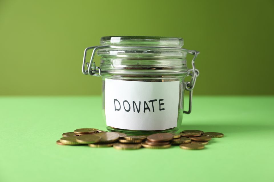 Donation jar with coins on green background close 2026 04 10 20 03 35 utc