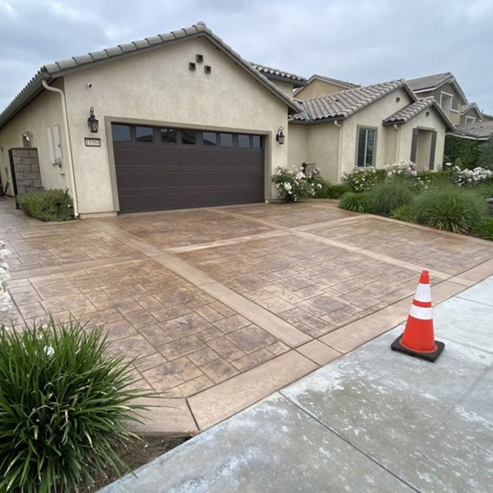 Stamped concrete driveway with custom border design in front of residential home