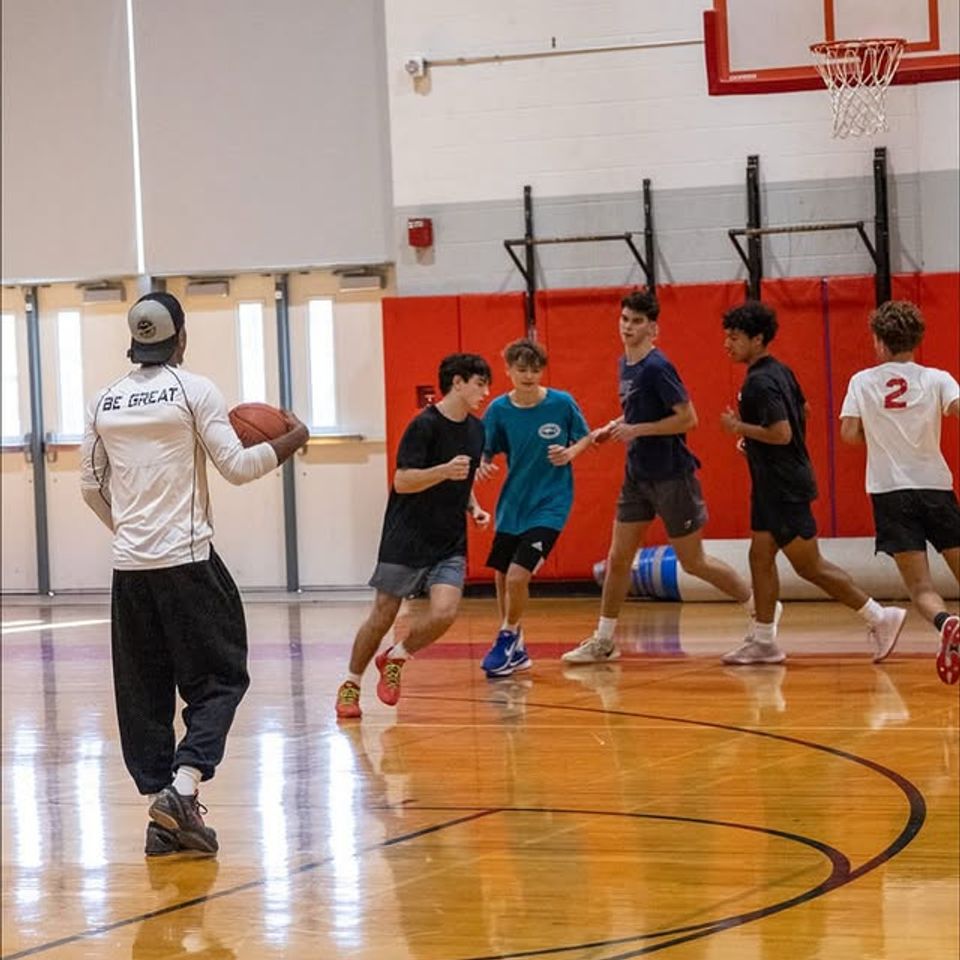 Xavier Allen training students in a basketball gym