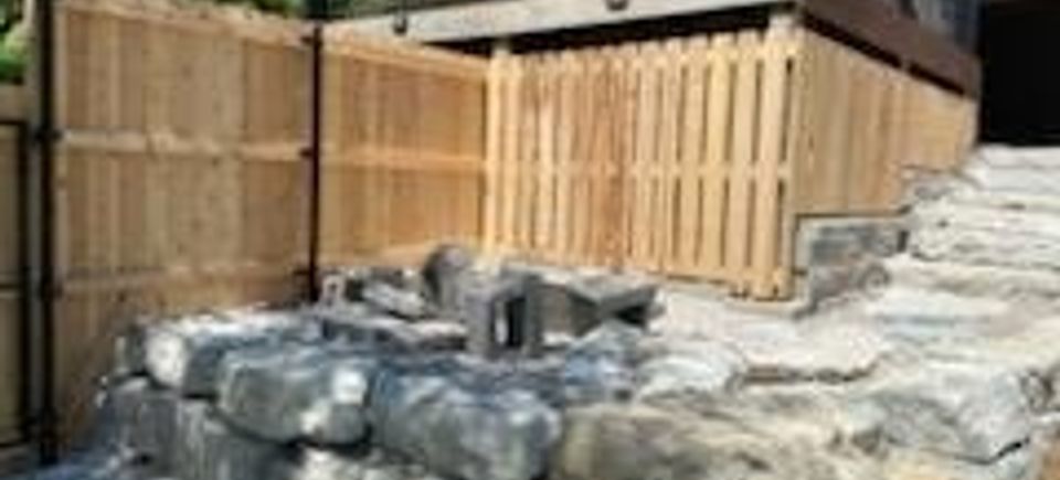 Challenging privacy fence install on rock landscape