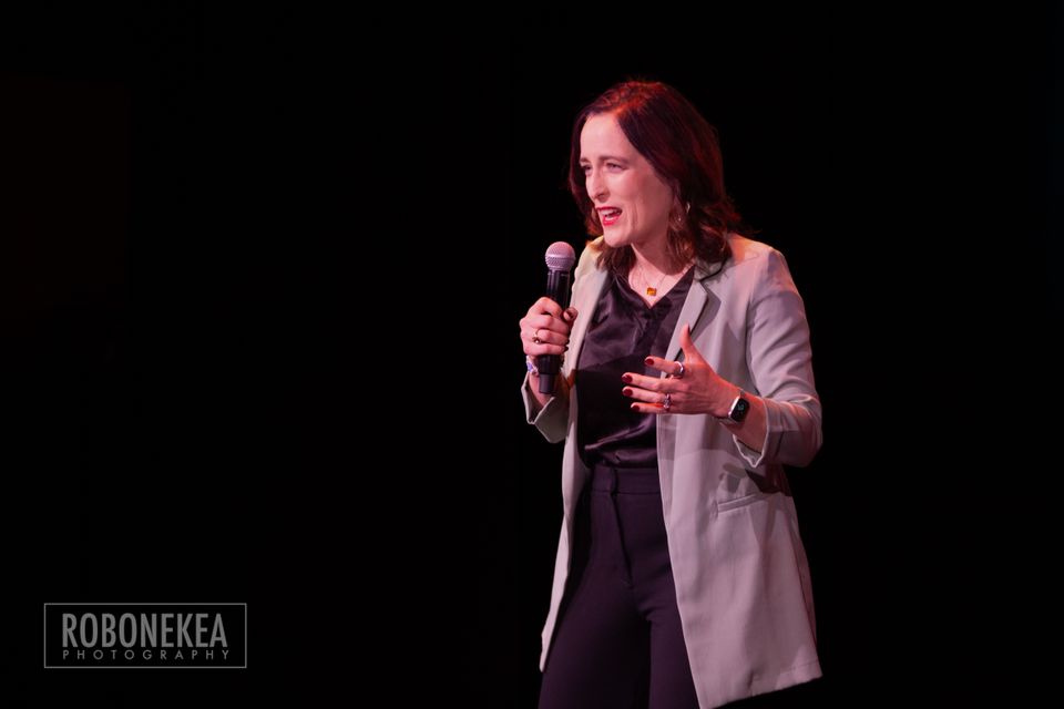 woman with microphone speaking to a group
