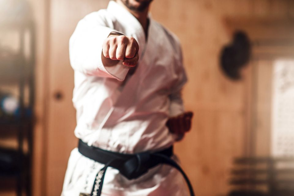 A karate black belt student executing a forward punch