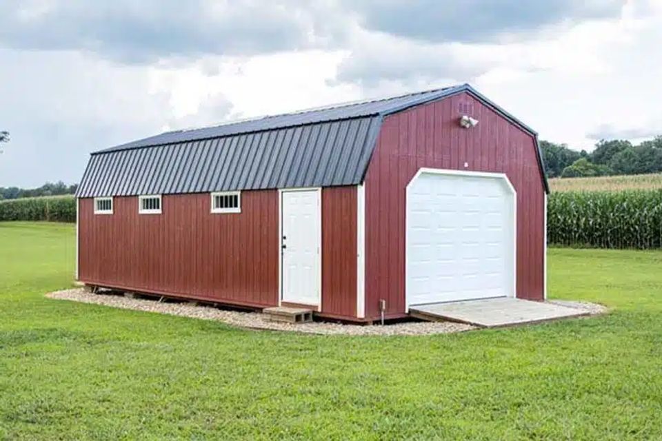 Red high wall garage with white overhead door and loft windows on an East Tennessee property