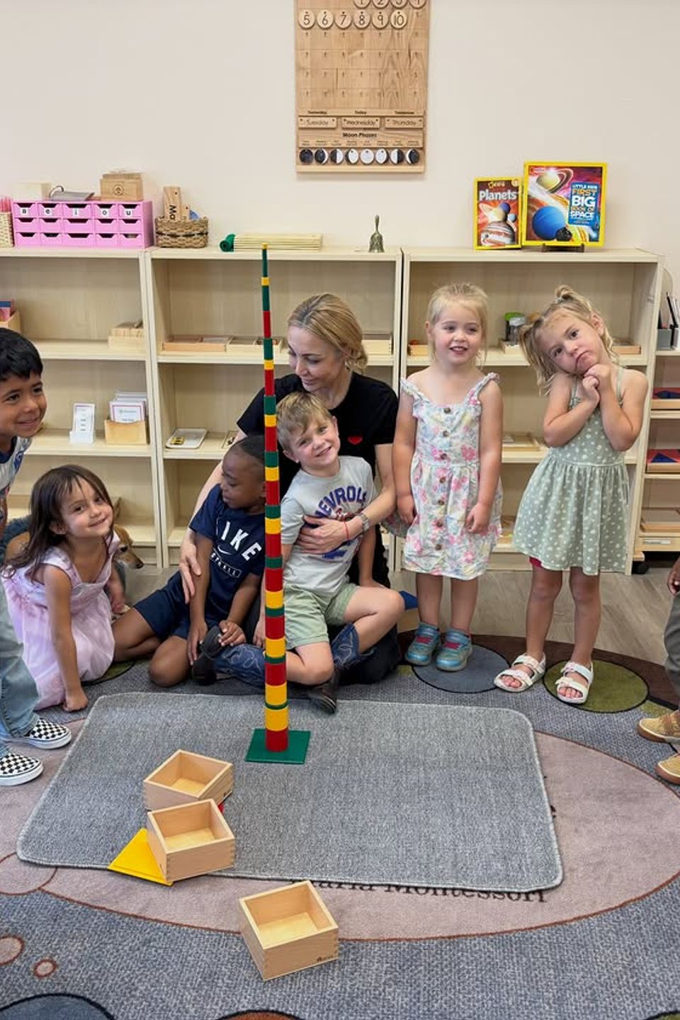 Teacher and preschool class gathered around a completed bead tower in a Montessori classroom in Palmdale CA