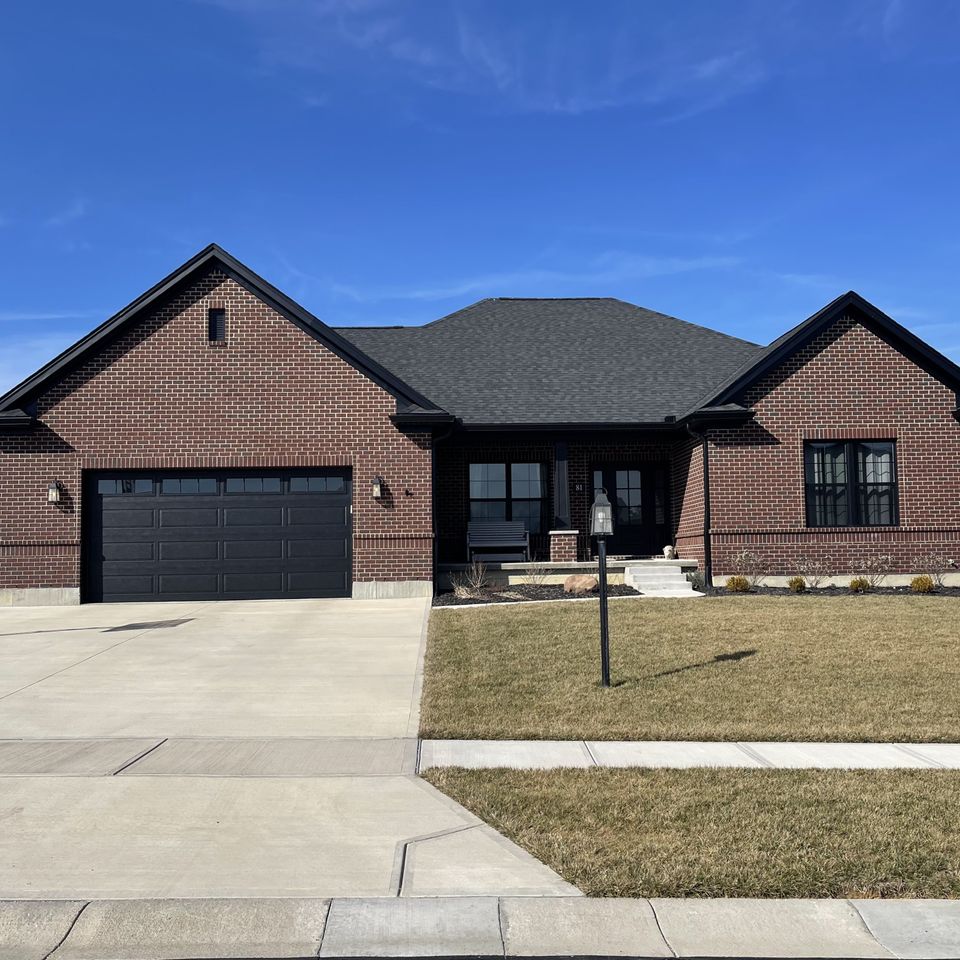 Brick ranch-style home with a newly installed gray architectural asphalt shingle roof by E & D Roofing, Inc.