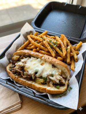 Best Philly in Lewisville, Texas Philly cheesesteak sandwich with grilled beef, peppers, onions, melted white cheese, and French fries from Wing Dash in Lewisville, Texas.
