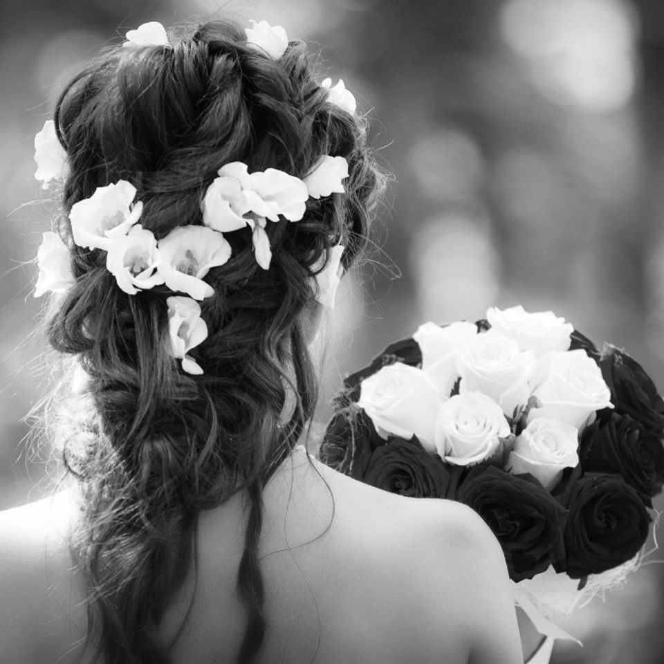 Bridal updo with white orchids and roses bouquet styled for wedding hair service in Columbiana AL