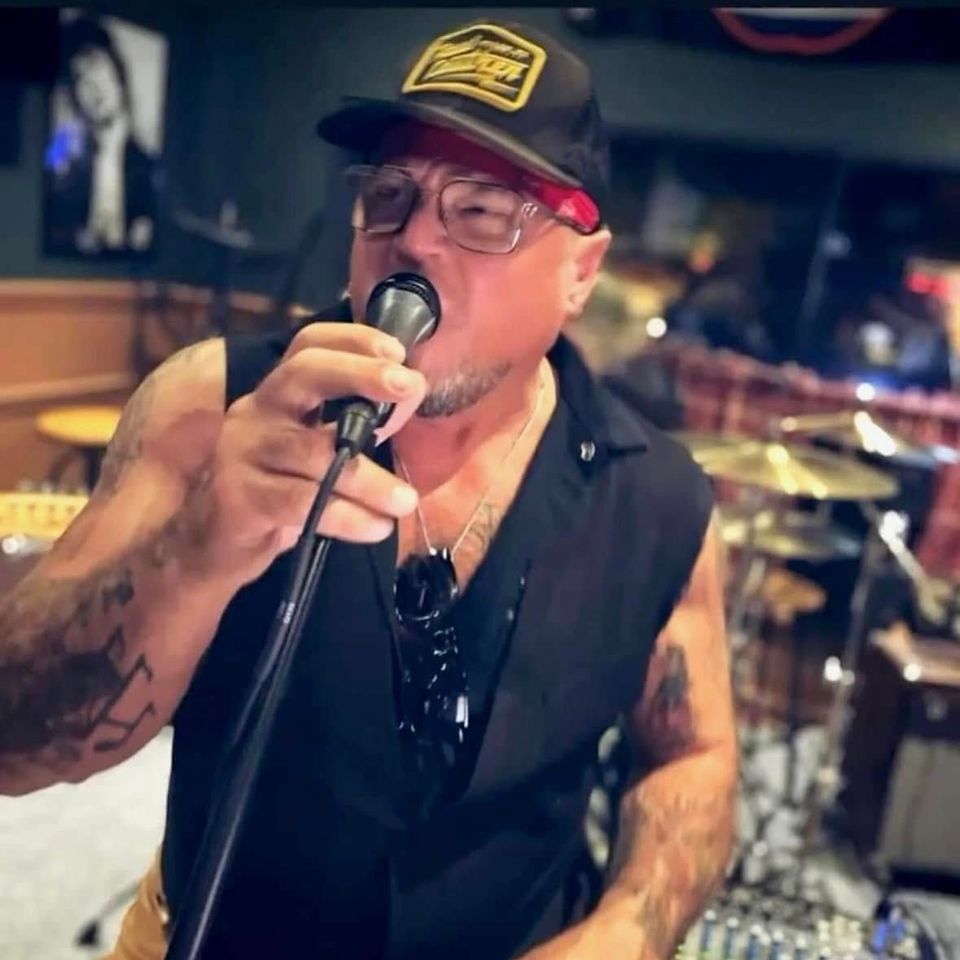 Roadside lead singer performing into a microphone at a Long Island pub gig