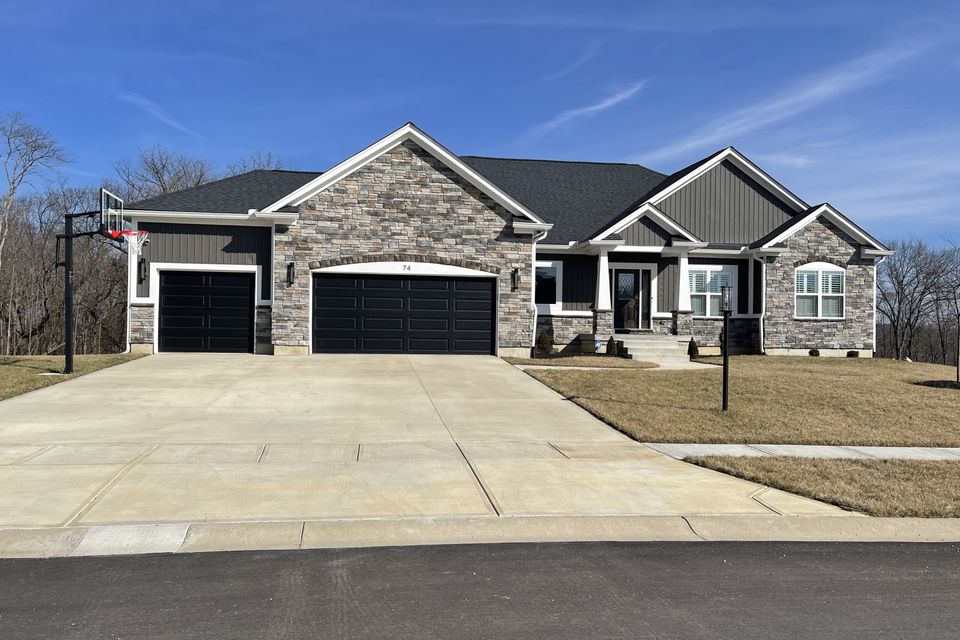 Stone-front home with a professionally installed dark gray architectural asphalt shingle roof by E & D Roofing, Inc.