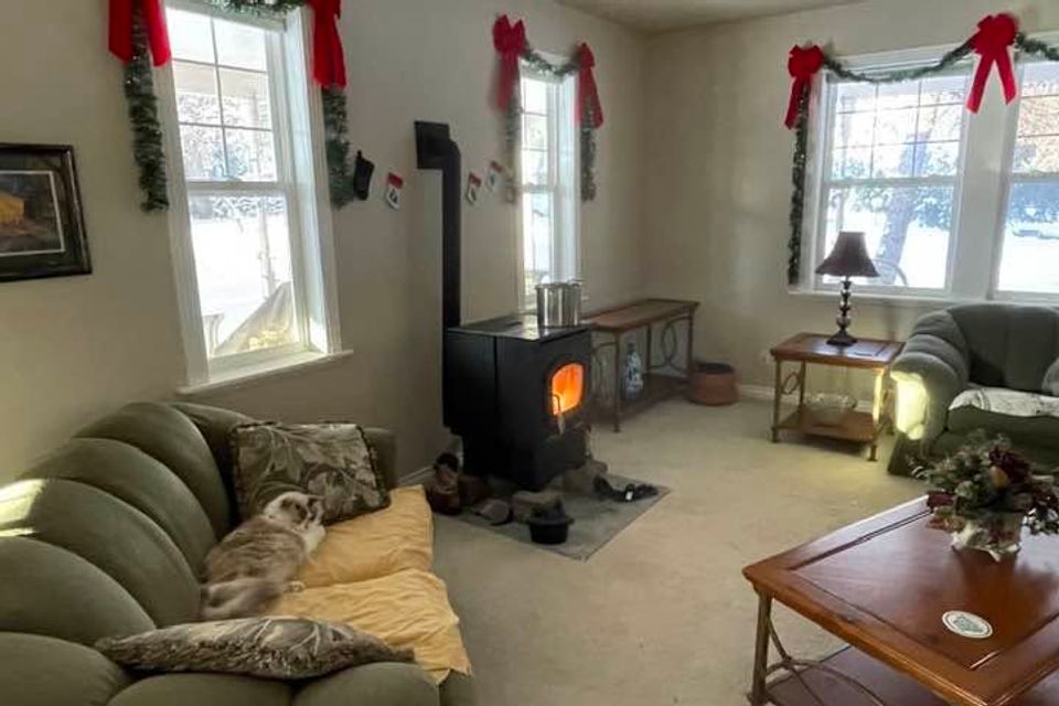 Cozy living room with wood stove and holiday decor inside a custom built home