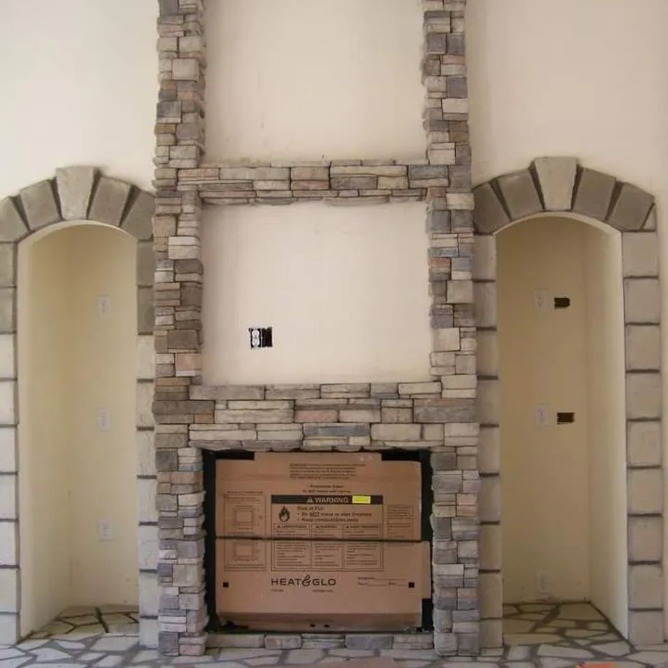 Interior fireplace surrounded by stacked veneer stone with matching stone arches and hearth.