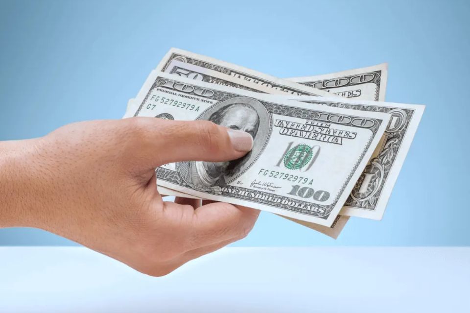 Person holding hundred dollar bills