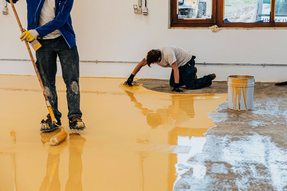 Vistacreate 416744020 stock photo worker coating floor self leveling epoxy resin industrial workshop