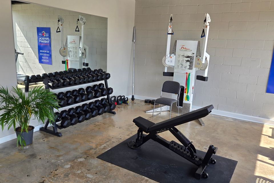 Free weights and strength training area at Mid-City Physical Therapy's Metairie clinic