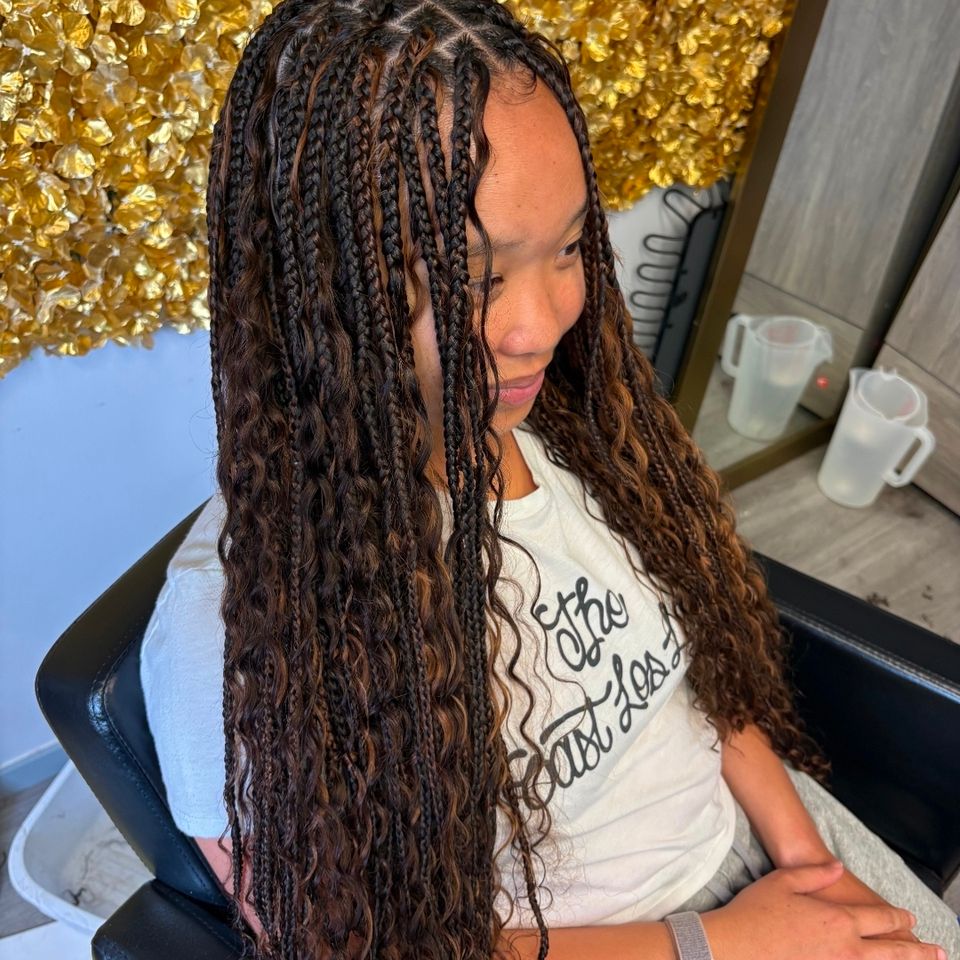 Client with dark brown boho knotless braids styled at hair braiding salon in Los Angeles CA