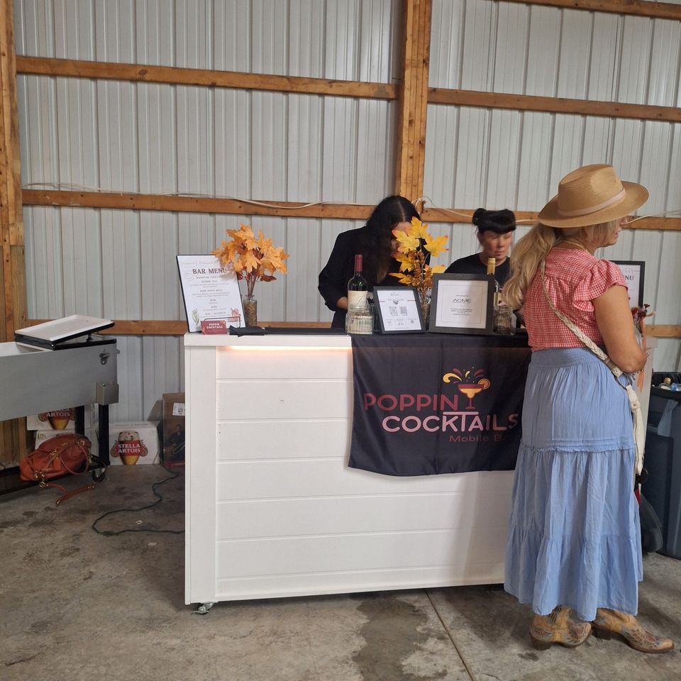 Close view of a 6ft wooden bar setup with a guest being served a drink