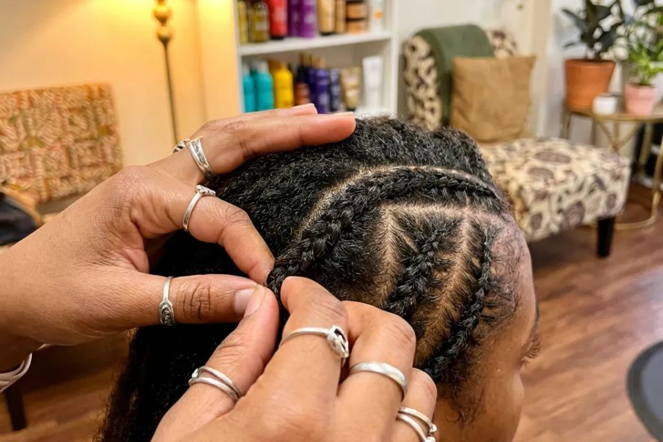  Professional African hair braiding salon doing stitch braids and cornrows close up
