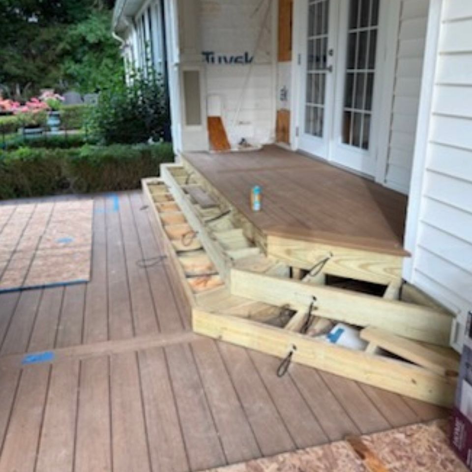 Pressure-treated wood step framing being built onto a composite covered porch deck on Cleveland's East Side