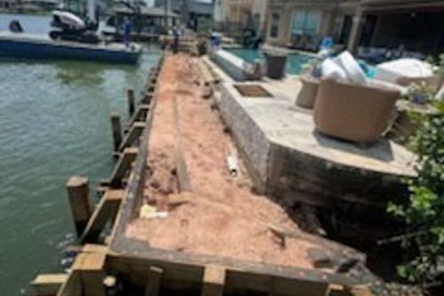 Trench cut for new timber bulkhead along canal in Baytown, TX