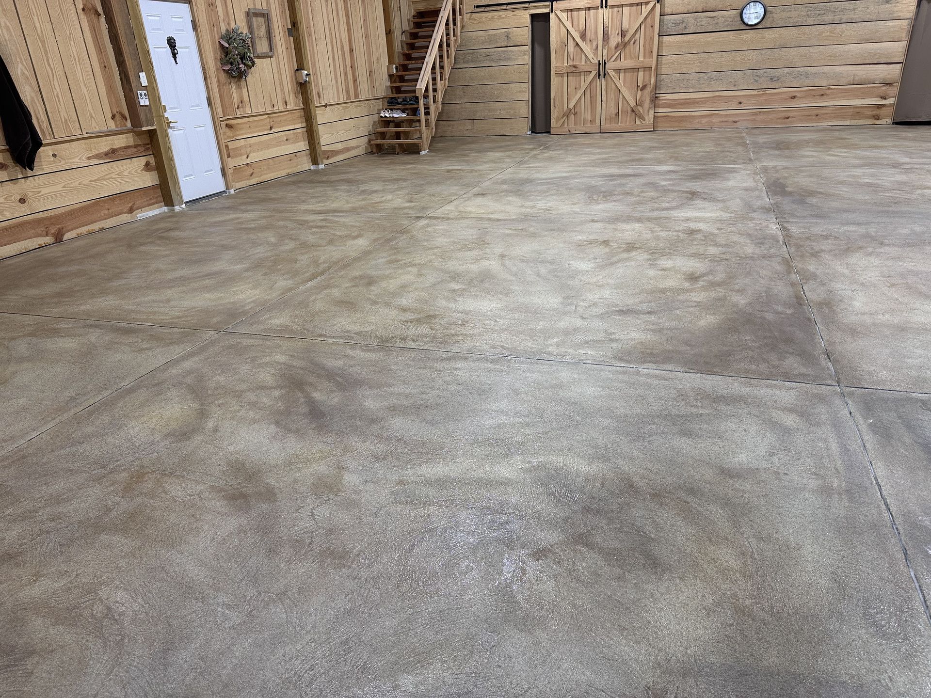 After: decorative garage floor with wood-paneled walls and staircase