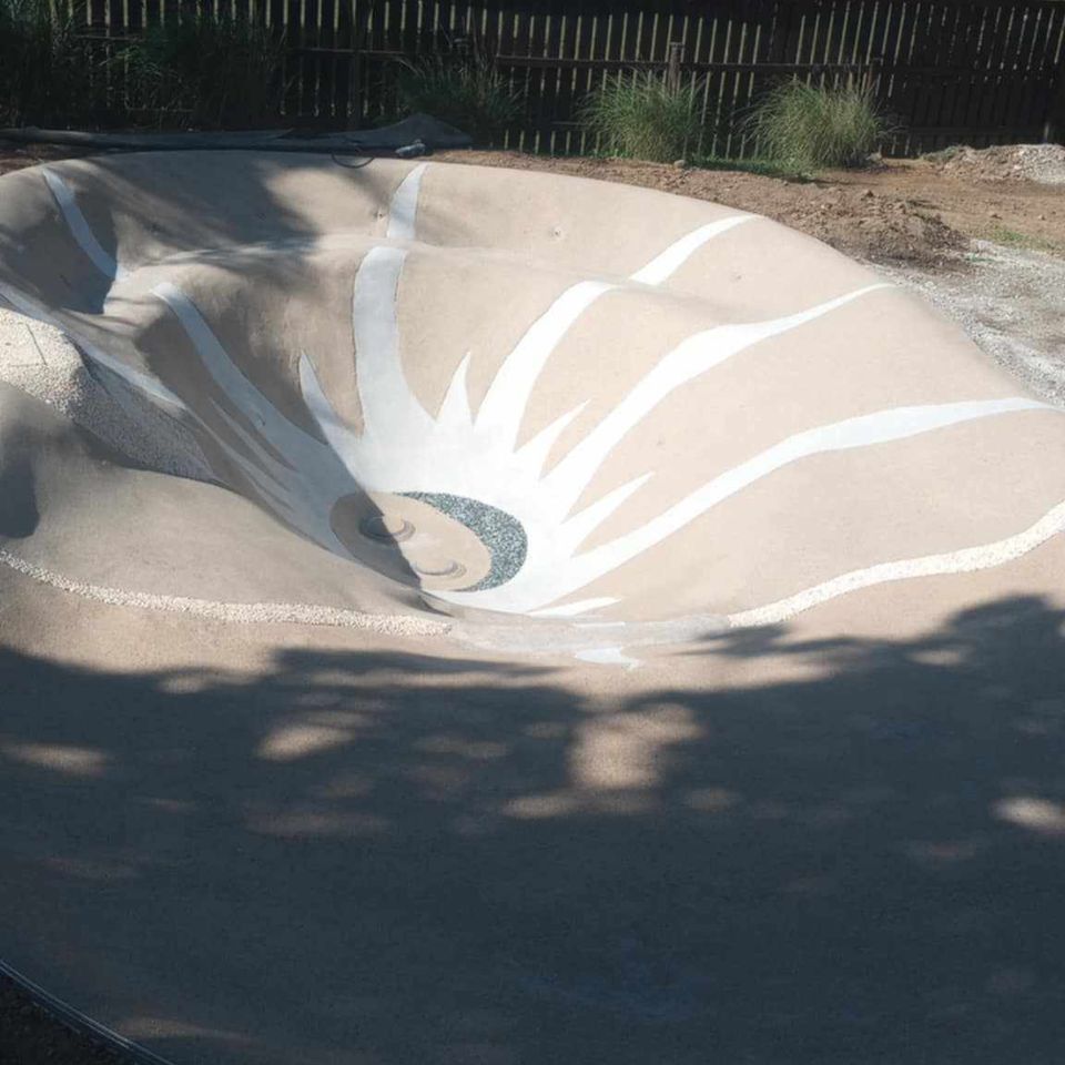 Sand Beach Pool featuring a custom sun design on the pool floor.