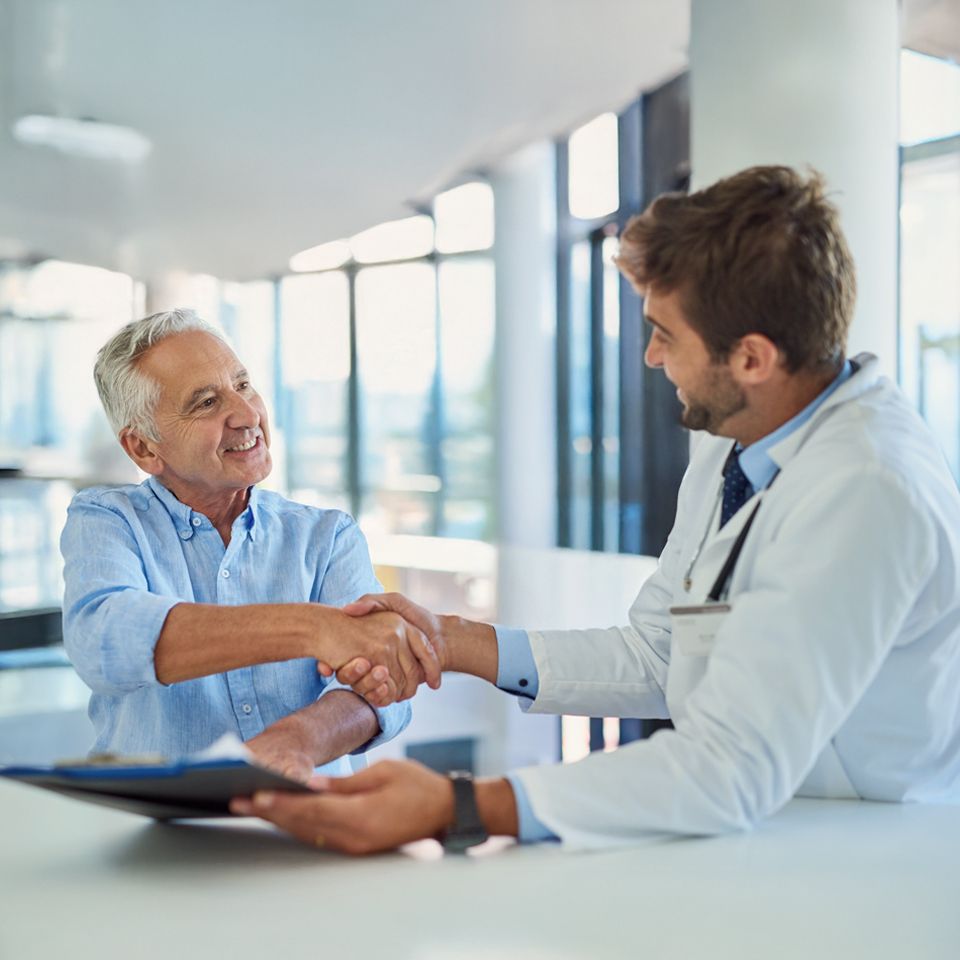 Medical team discussing senior home care plan with elderly patient