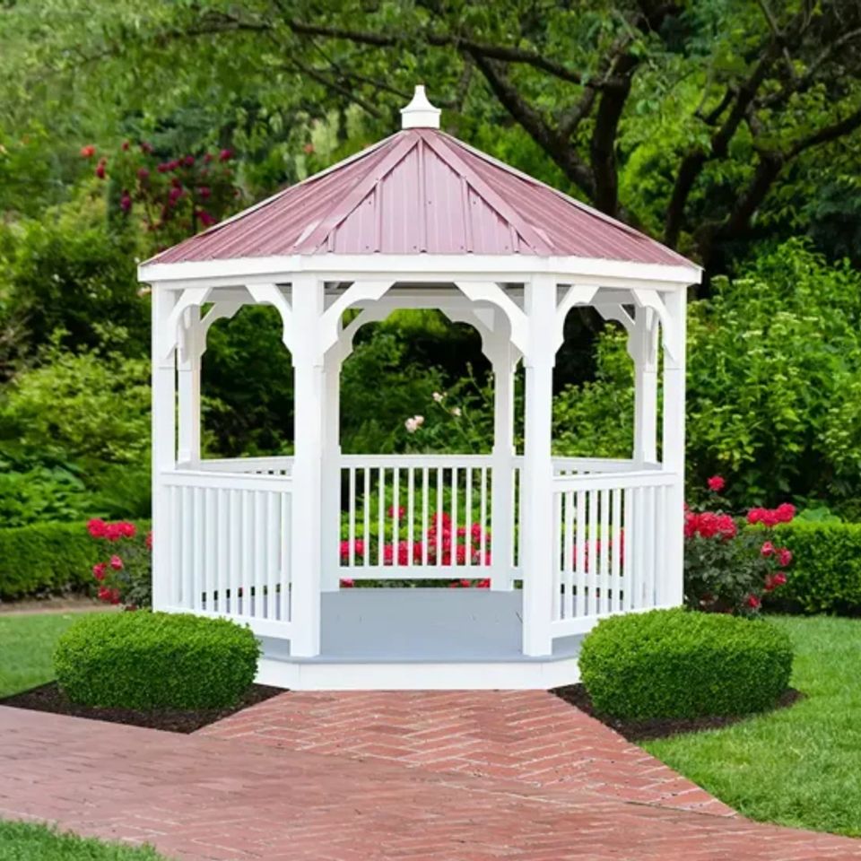 White vinyl gazebo with red metal roof and brick walkway in an East Tennessee garden
