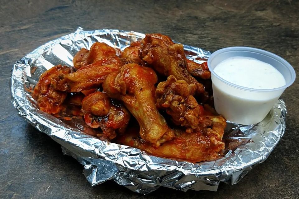 Basket of Jumbo Wings served with a side of dipping sauce at Cocca’s Pizza.