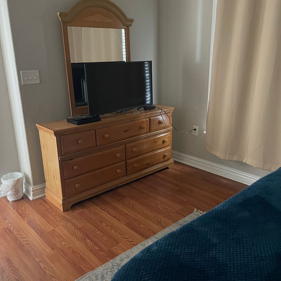 Bedroom with wood dresser and clean floor after house cleaning service in Virginia Beach VA