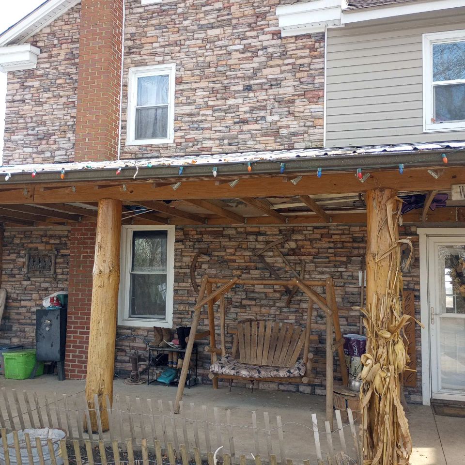 Home exterior featuring multicolored veneer stone along the walls and around the windows.