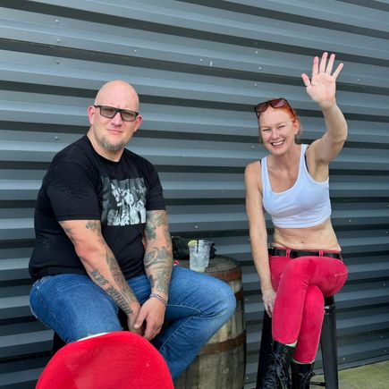 Two guests seated outdoors, smiling and enjoying a community event.