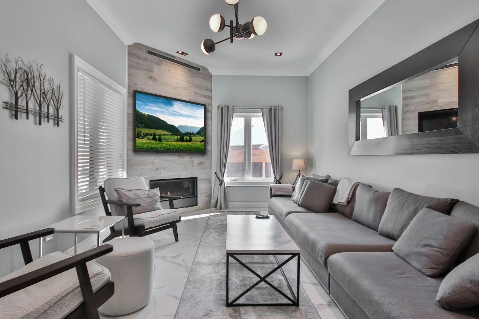 Whole-home audio and video setup with multiple speakers and displays, controlled by a smart device.