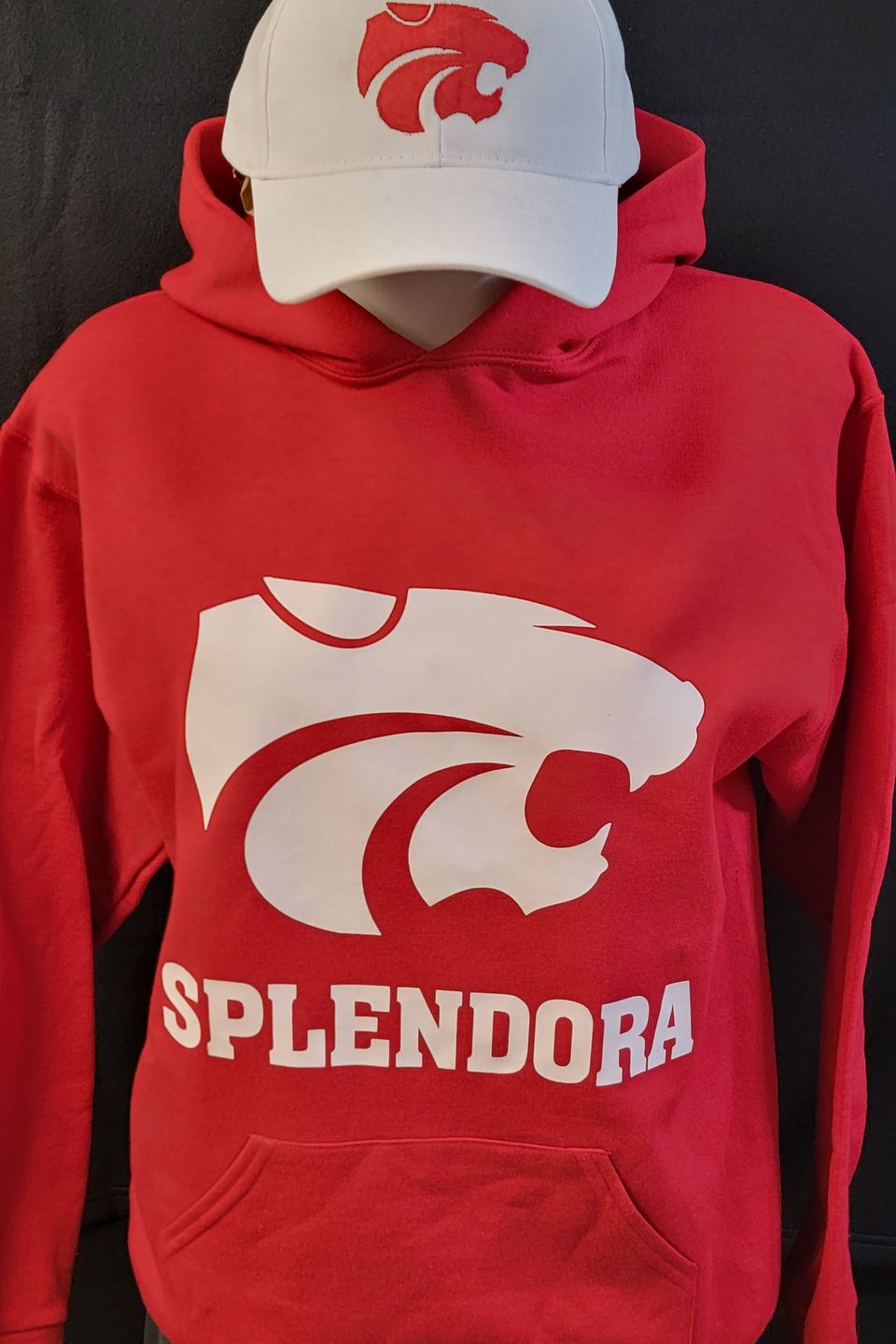 Example of Direct to Film (DTF) transfer - Splendora ISD HS logo on a red hoodie, & embroidered logo on a white cap 