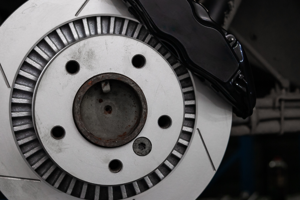 Close-up of a vehicle brake rotor and brake caliper during brake service and repair.