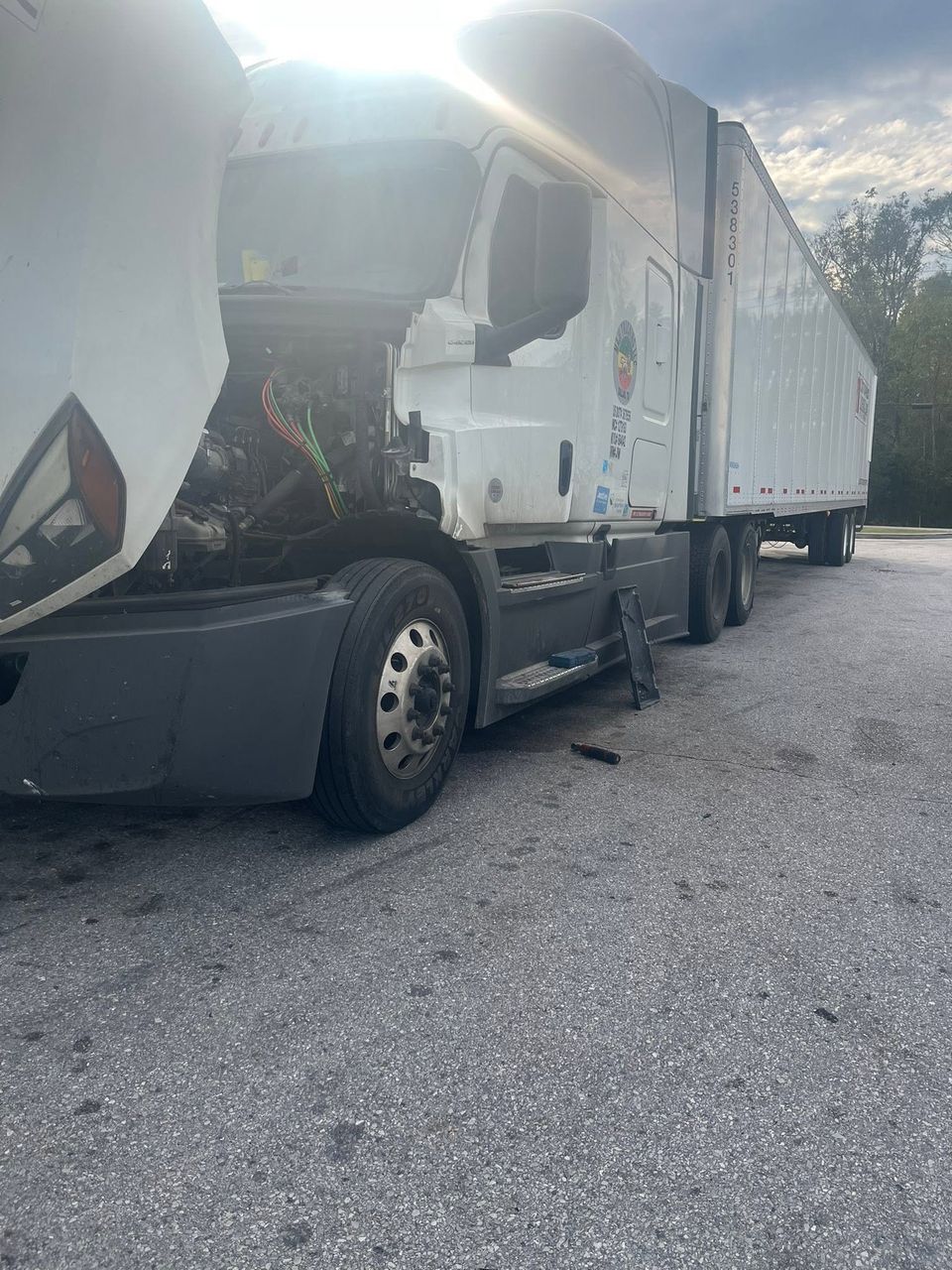 White Freightliner semi-truck with hood open during roadside diesel repair in Arab Alabama
