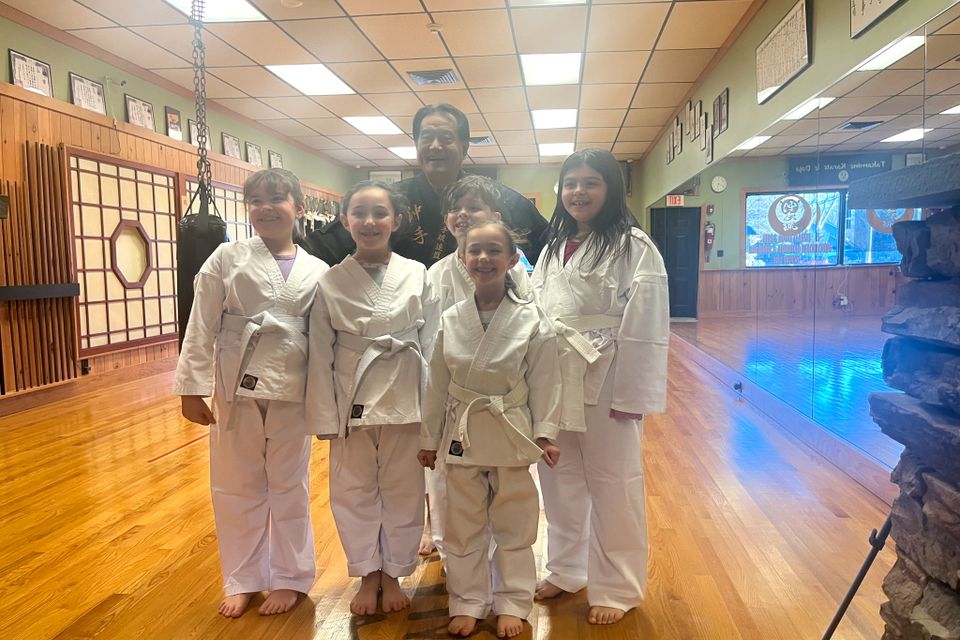 Hanshi Takamine and the kid karate students, posing for a photo