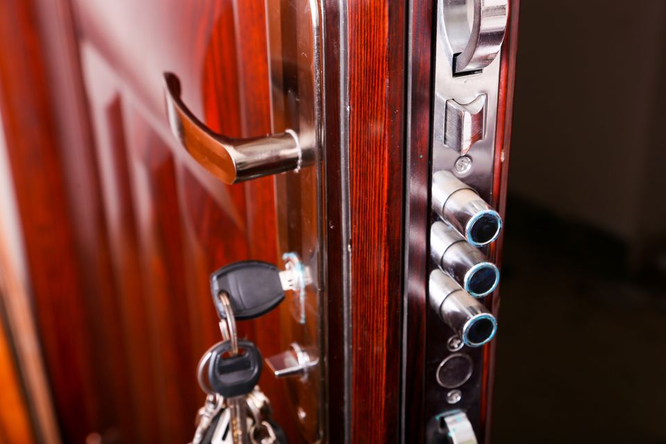 Opened door with keys hanging out, showcasing the prominent deadbolts and the expertise of a key locksmith.