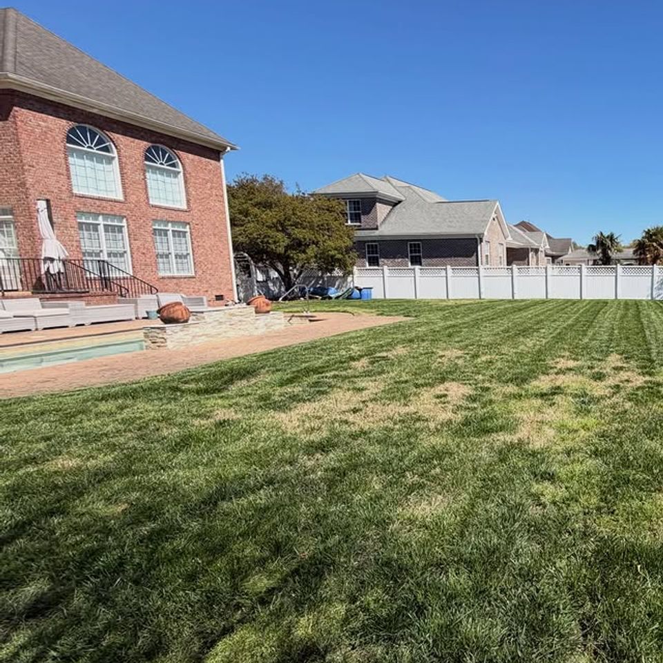 Newly cut grass for a backyard, sun shining, done by Get A Mow On Lawn Care LLC of Chesapeake VA
