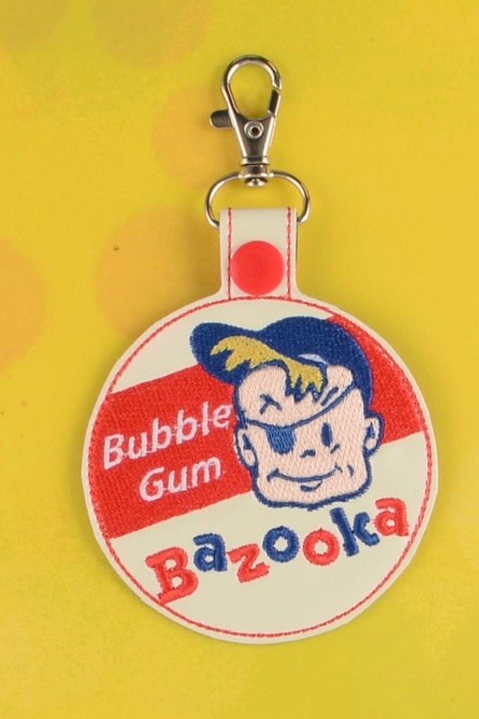 Custom embroidered Bazooka Bubble Gum keychain with vintage-style logo and character design.