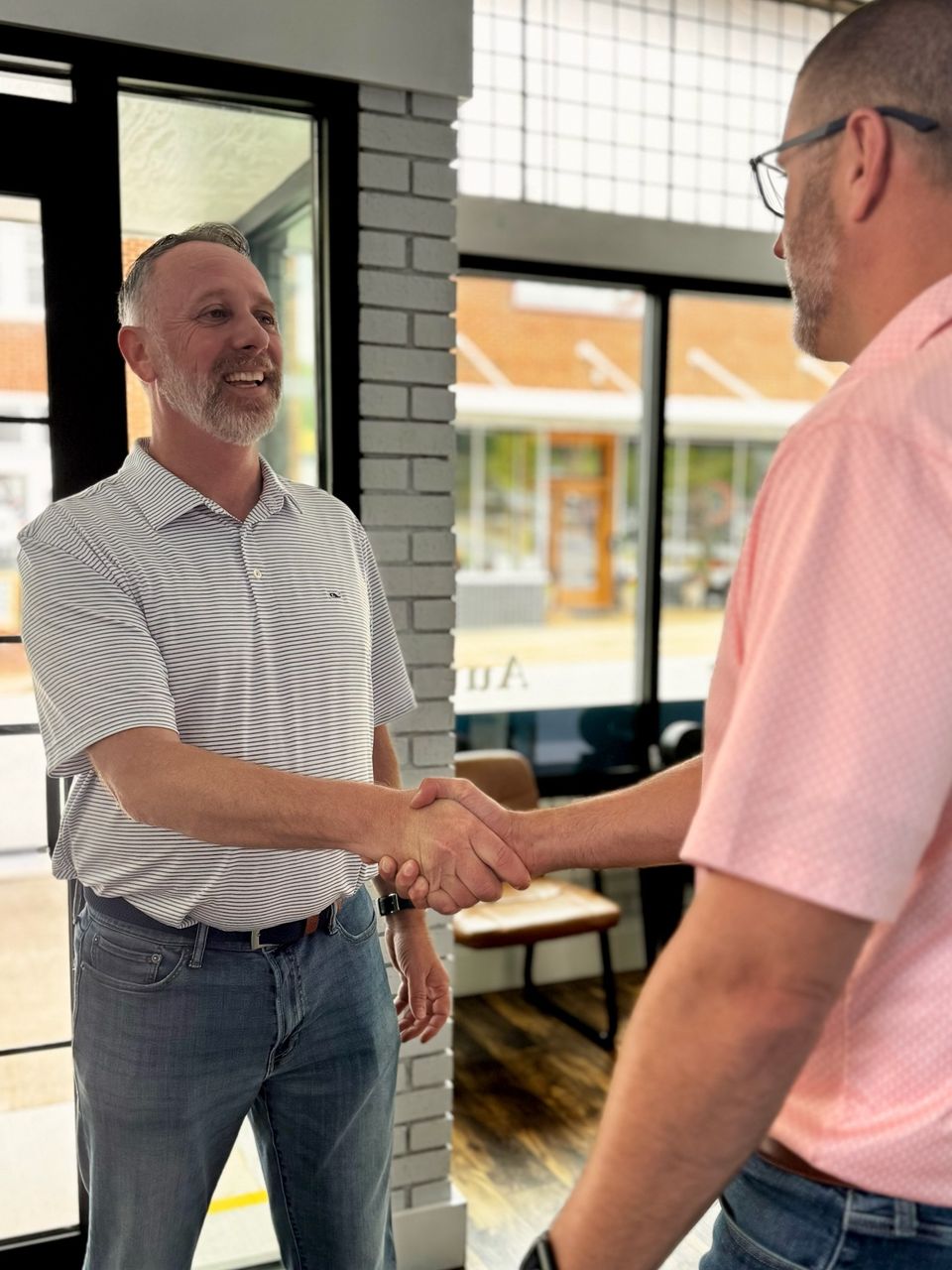 Steven Stewart shaking hands with a client in his office, representing trusted, personalized service at Stewart & Associates Insurance. Work with a local agent who puts your needs first.