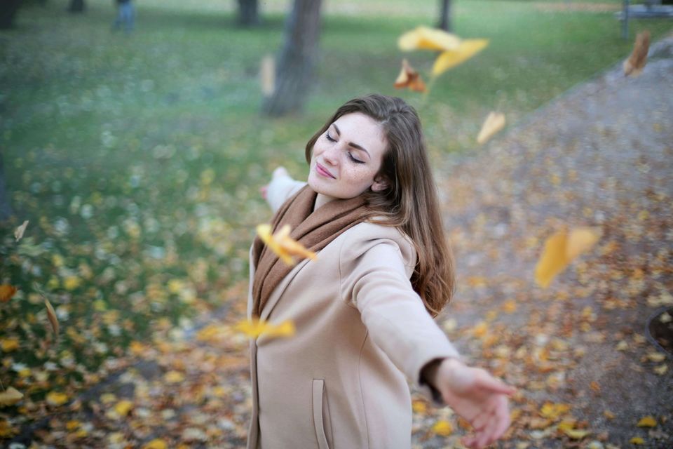 Happy Woman with falling yellow Leafs after depression treatment