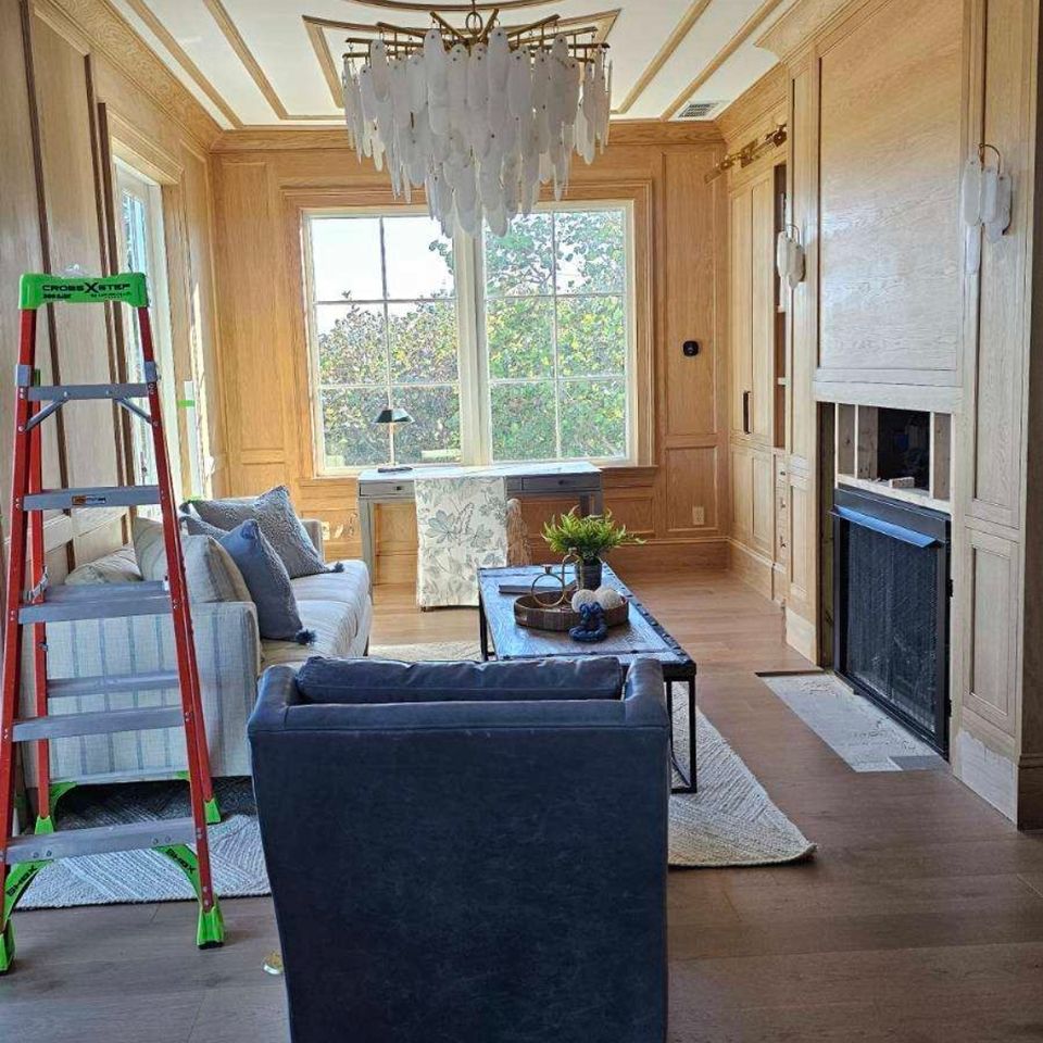 Wood paneled living room with ladder during trim installation in a Chagrin Falls OH home