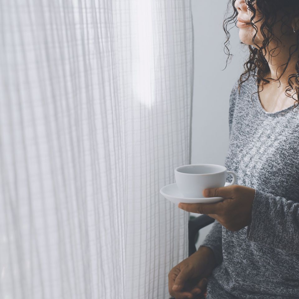 Woman drinking coffee cup window home