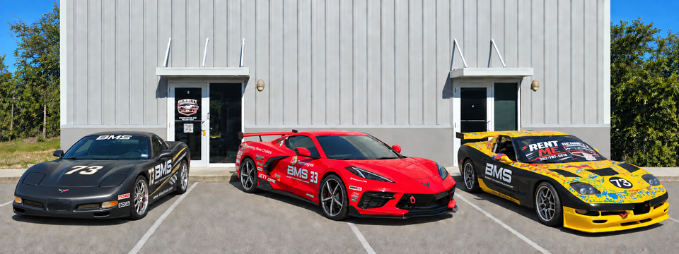 Bennett motorsports corvette race car rentals featuring black betty, scooter rosso, and brian parked outside the bms facility.