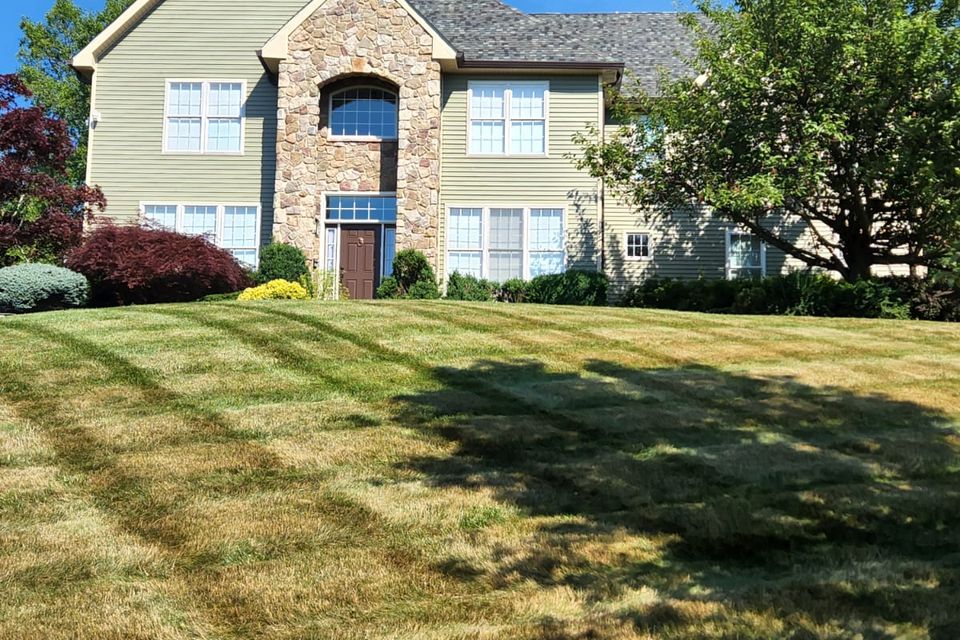 Custom luxury home with stone façade and green lawn in Sullivan County.