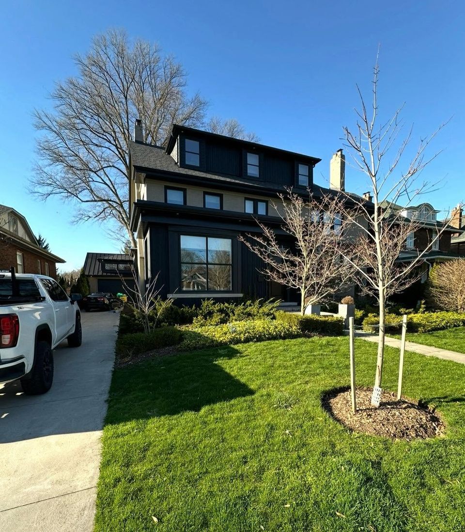Black board and batten three-storey home with clean windows after exterior cleaning in Tillsonburg