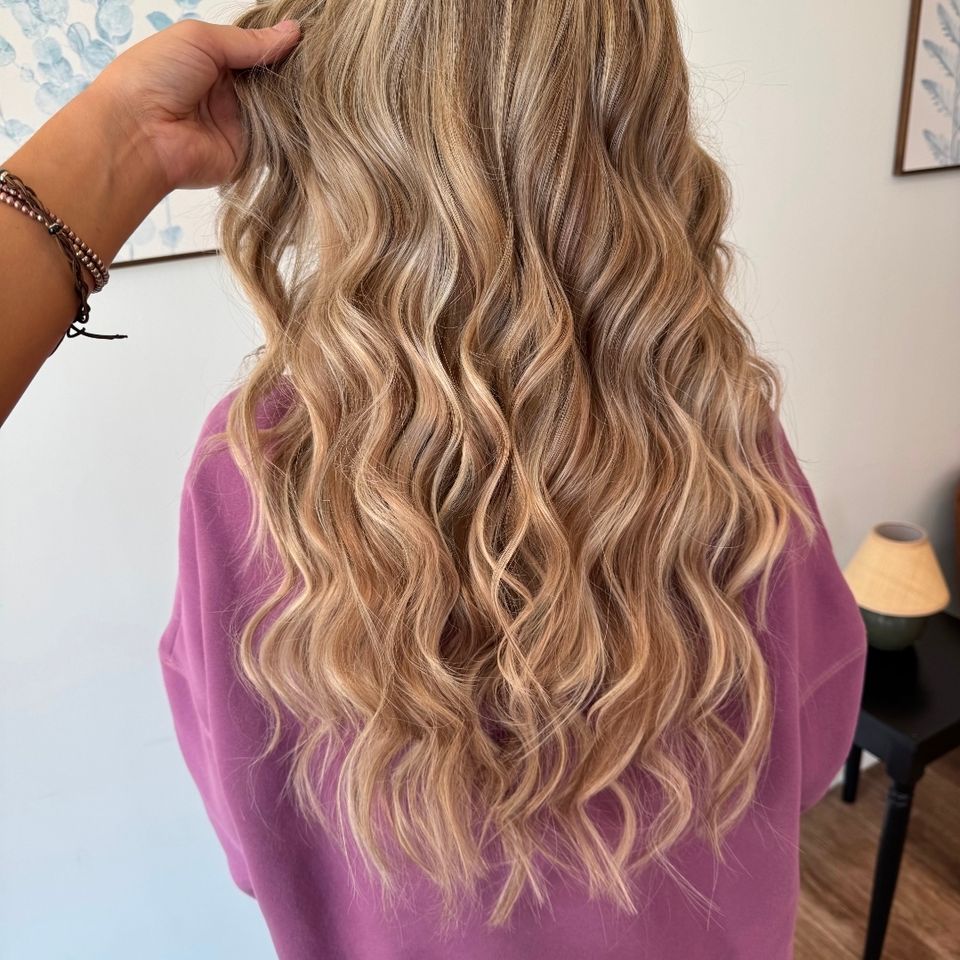 Back view of long wavy blonde balayage hair styled at hair salon in Columbiana AL