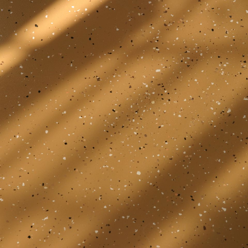 Close-up of an EverCoat Flooring surface with a tan decorative flake finish.